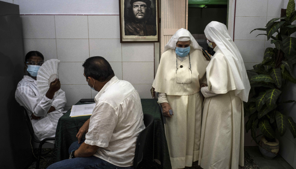 Two nuns are vaccinated after being vaccinated at a vaccination center in Cuba with a picture of Che Guevara on the wall from the back.  Photo: Ramon Espinosa/AP/NTB