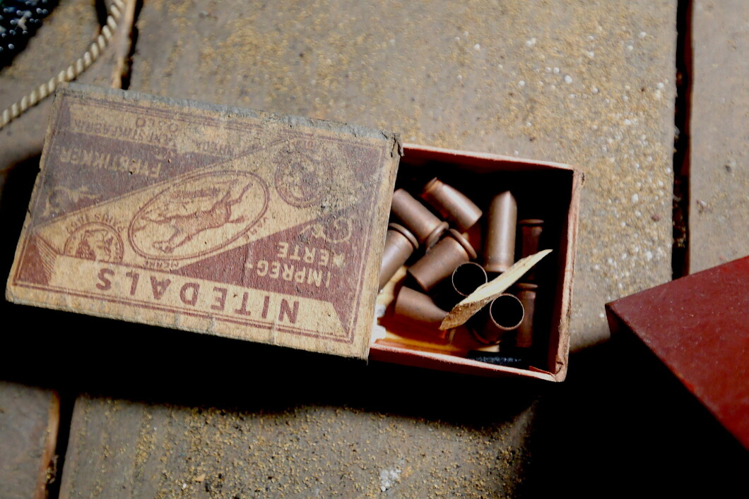 Old matchbox with used cartridge cases.