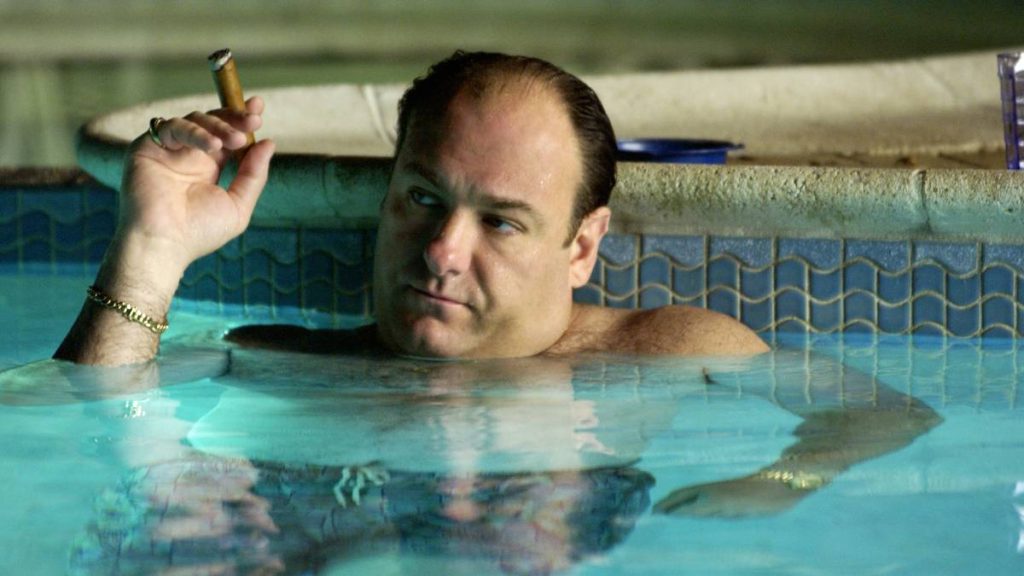 James Gandolfini som Tony Soprano i et svømmebasseng mens han røyker sigar.
