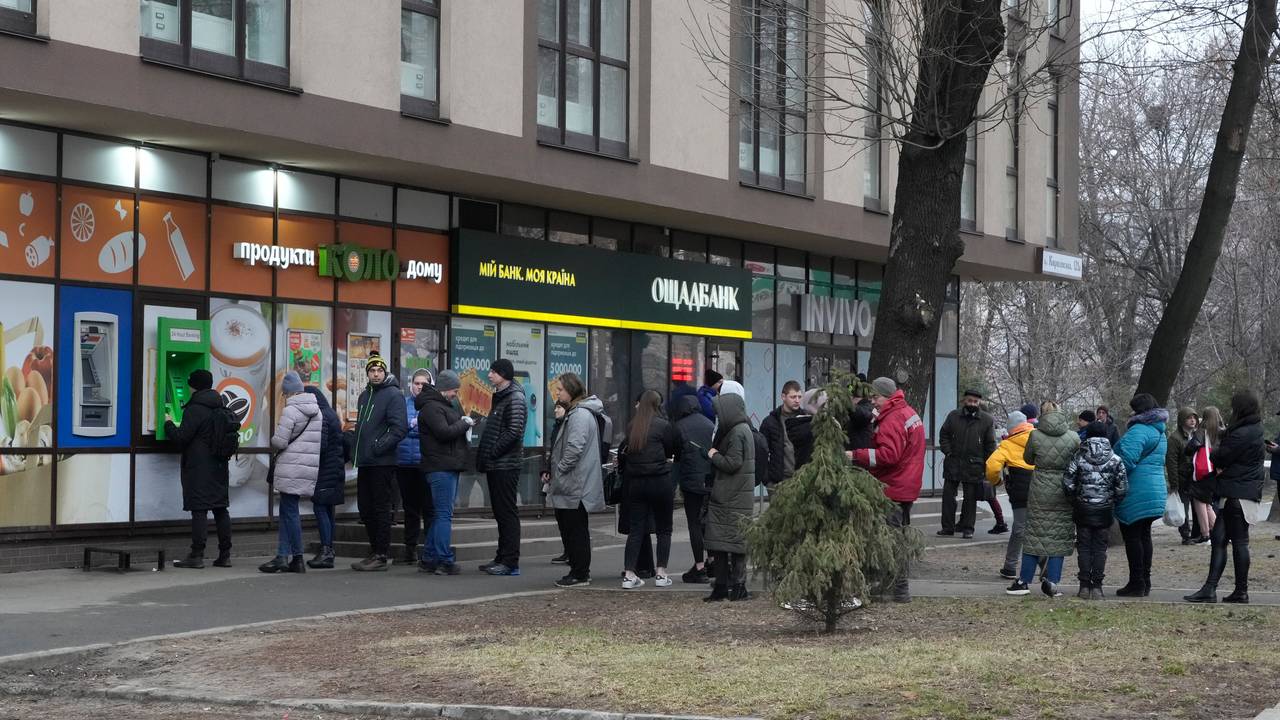People queue to withdraw money from an ATM in the Ukrainian capital, Kiev. 