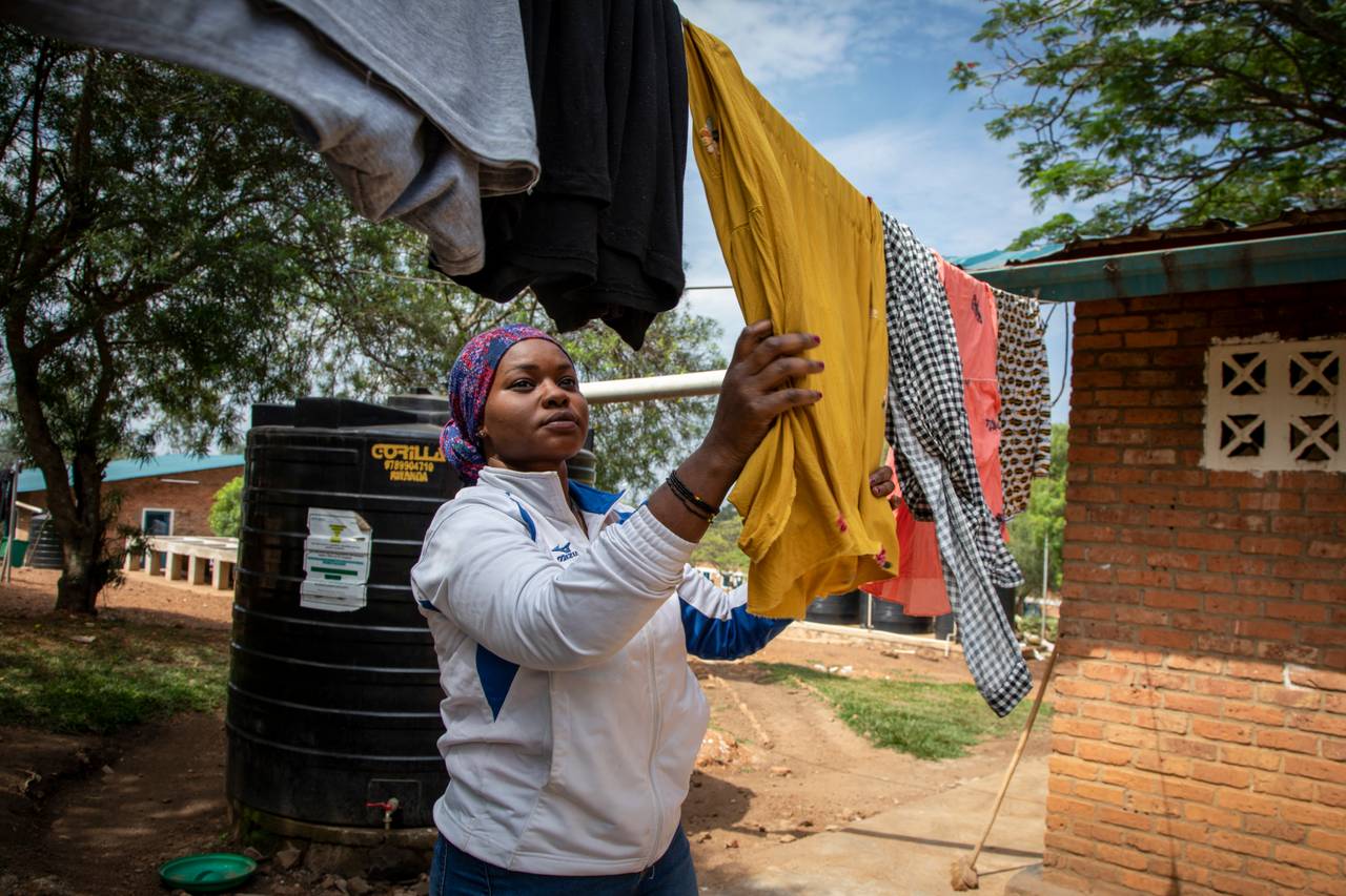 An asylum-seeker who was evacuated from Libya to Rwanda hangs her clothes to dry. 