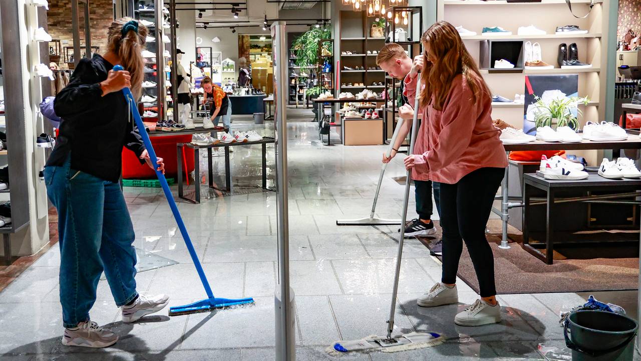 Employees at the Tonsen shoe store in the Darkwartlet shopping center mop up water from the floor after several areas of Kristiansand flooded on Friday afternoon. 