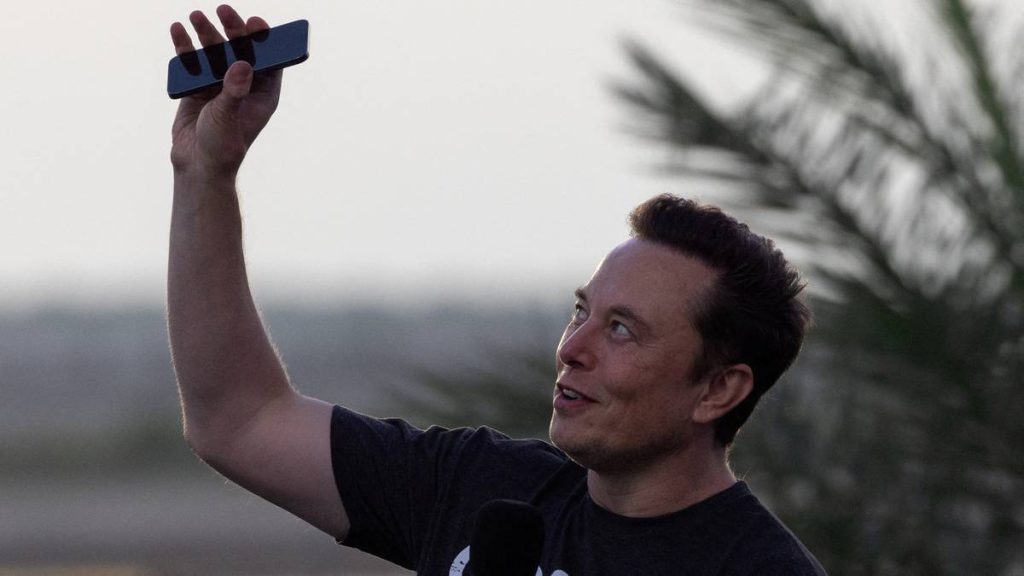 FILE PHOTO: Musk raises phone towards the sky at SpaceX Starbase in Brownsville, Texas