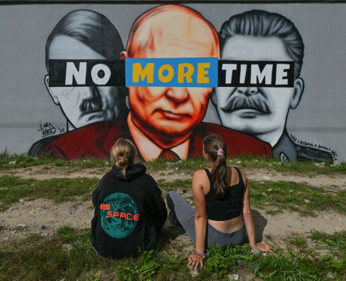 Hitler, Putin and Stalin: Two people look at a mural of Hitler, Putin and Stalin in Gdansk, Poland in September.  Above the three faces is written 