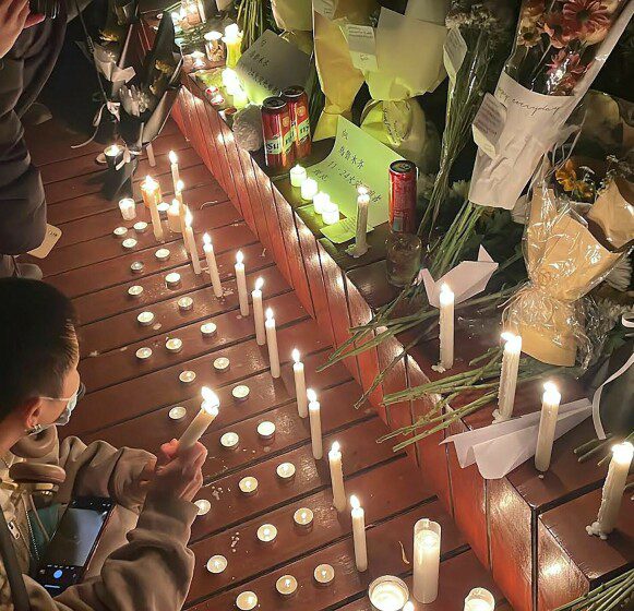 Souvenir: Protesters in Beijing light candles and lay bouquets in memory of those who reached the fire in Urumqi.  Photo: Michael Zhang/AFP/NTB.