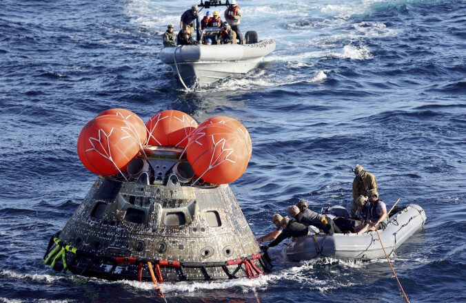 US Navy divers secure the spacecraft after it lands.  Photo: Mario Tama/POOL/AP